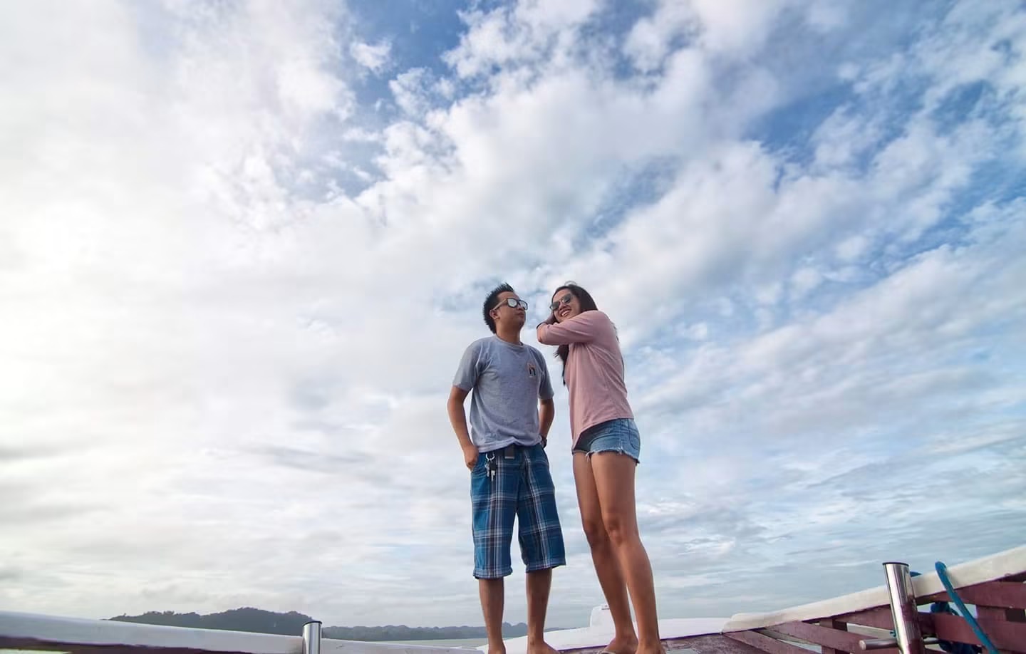 Rea and Charles on a boat under a cloudy sky