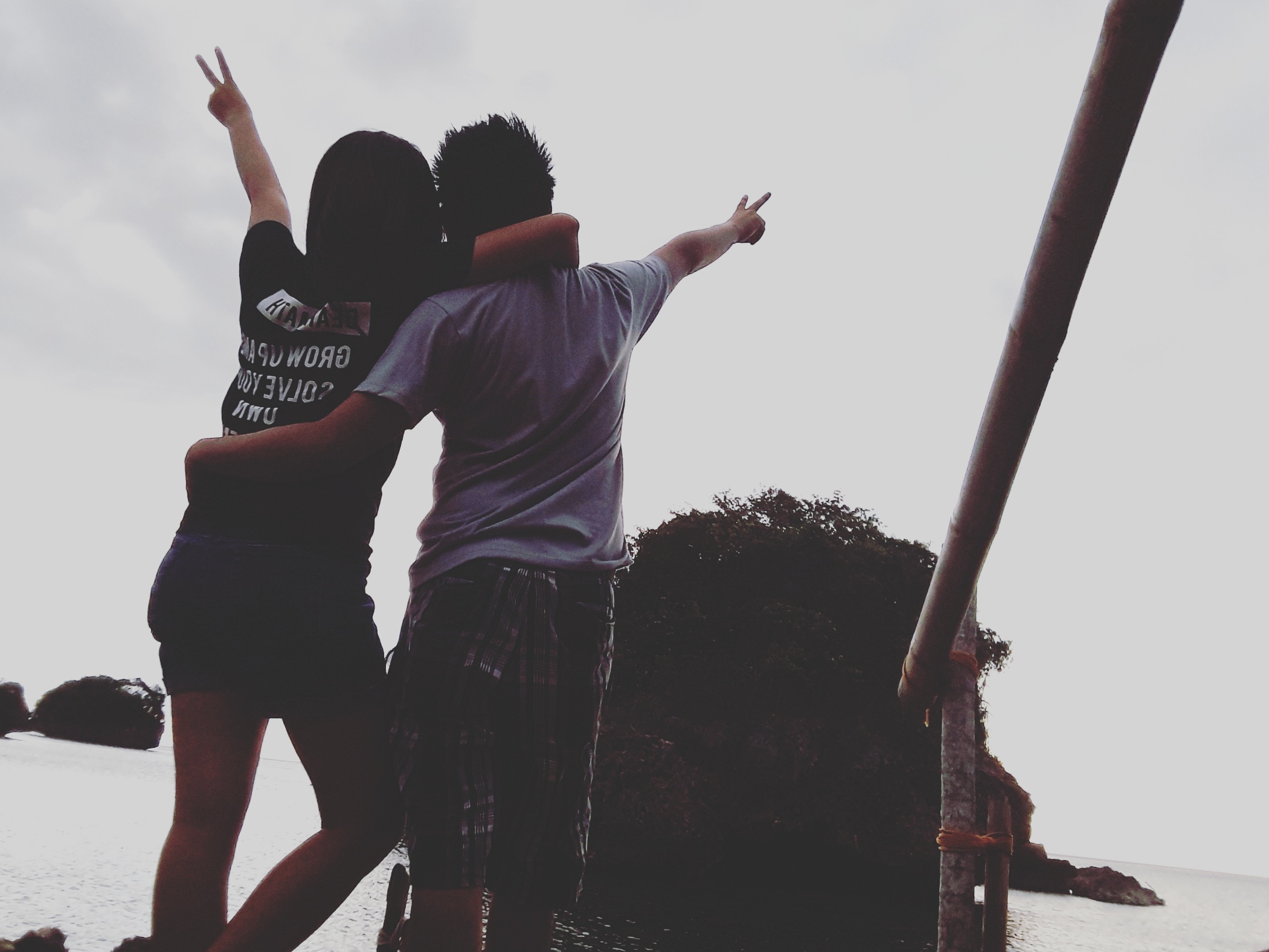 Rea and Charles by the sea, making peace signs